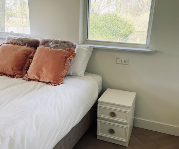 Slaapkamer met opgemaakt bed in De Weerribberhof